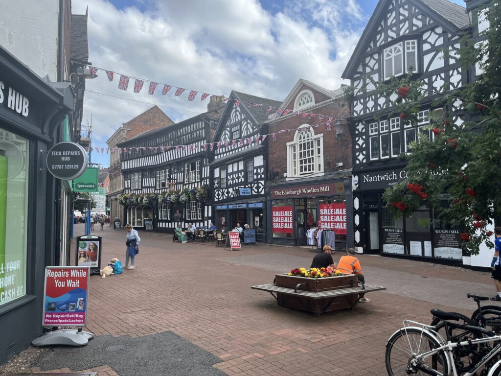 Attractive half timbered buildings in the centre of Nantwich. A few shoppers can be seen.